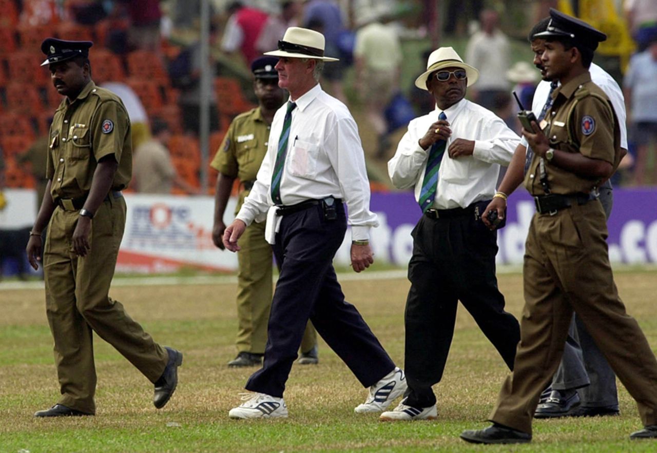 Rudi Koertzen and BC Cooray are escorted off the field by security officials after another wretched day for both of them, Sri Lanka v England 2nd Test, Kandy, March 10, 2001