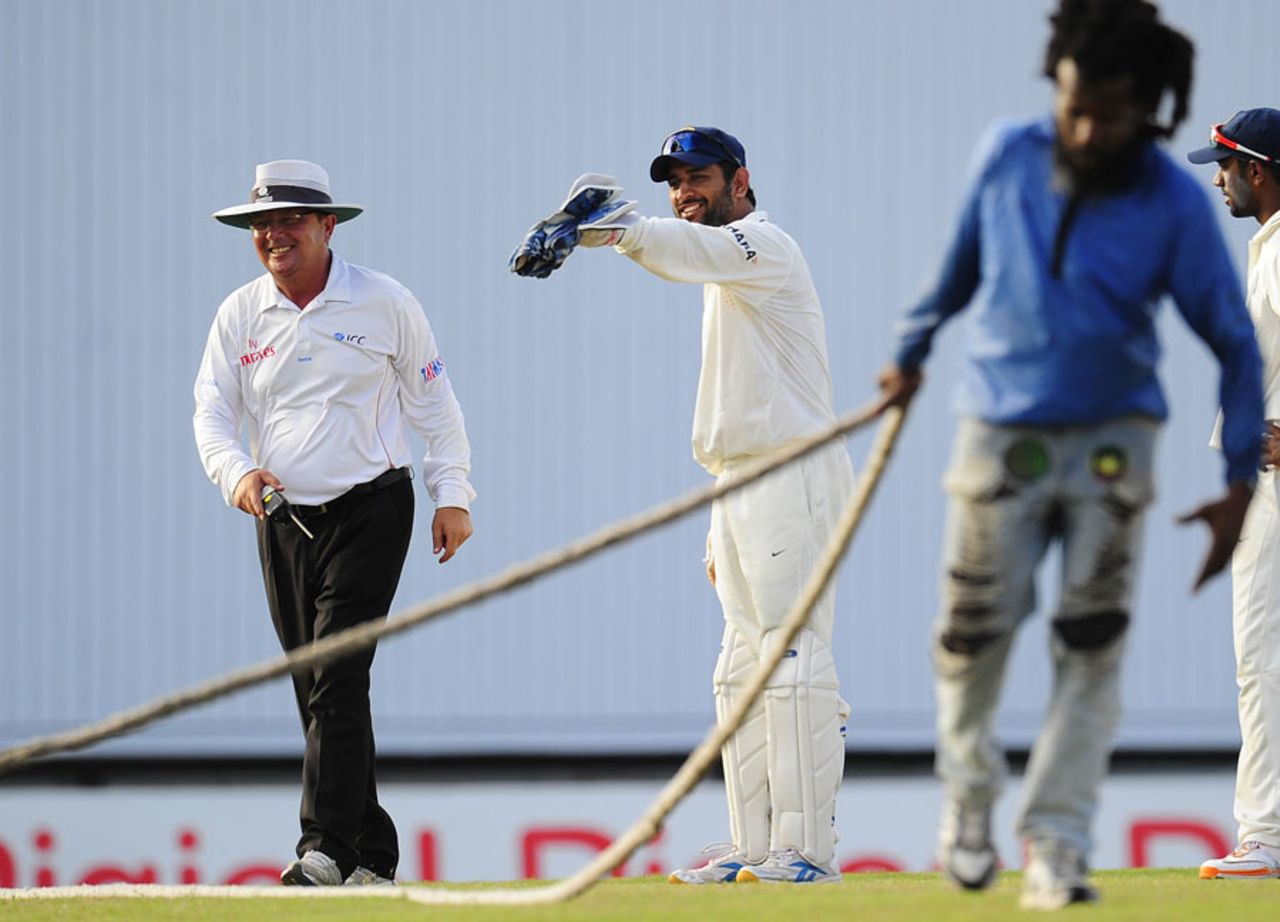 MS Dhoni points to umpire Ian Gould to some wet spots in the outfield after a rain interruption, West Indies v India, 2nd Test, Bridgetown, 5th day, July 2, 2011 