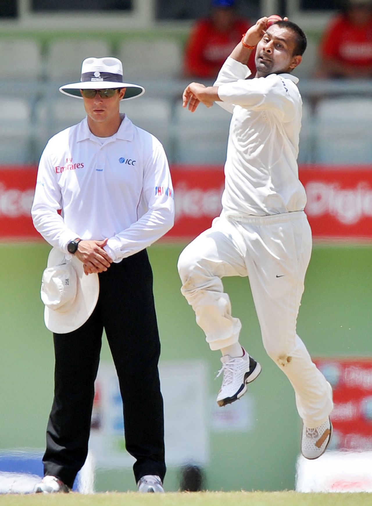 Praveen Kumar runs in to bowl as umpire Richard Kettleborough looks on, West Indies v India, 3rd Test, Dominica, 4th day, July 9, 2011
