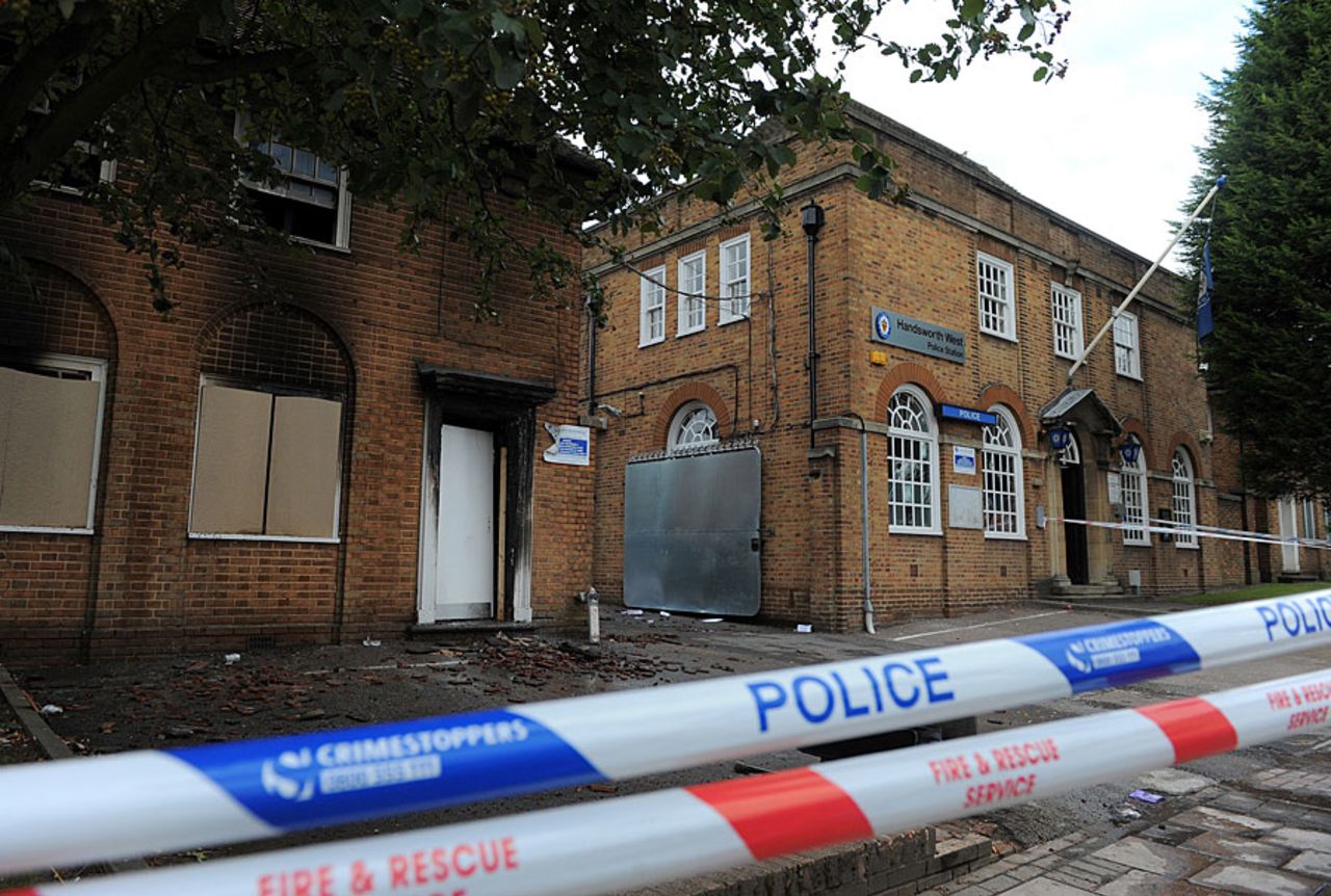 Police barricades outside an unmanned police station that was damaged during rioting in Birmingham, August 9, 2011