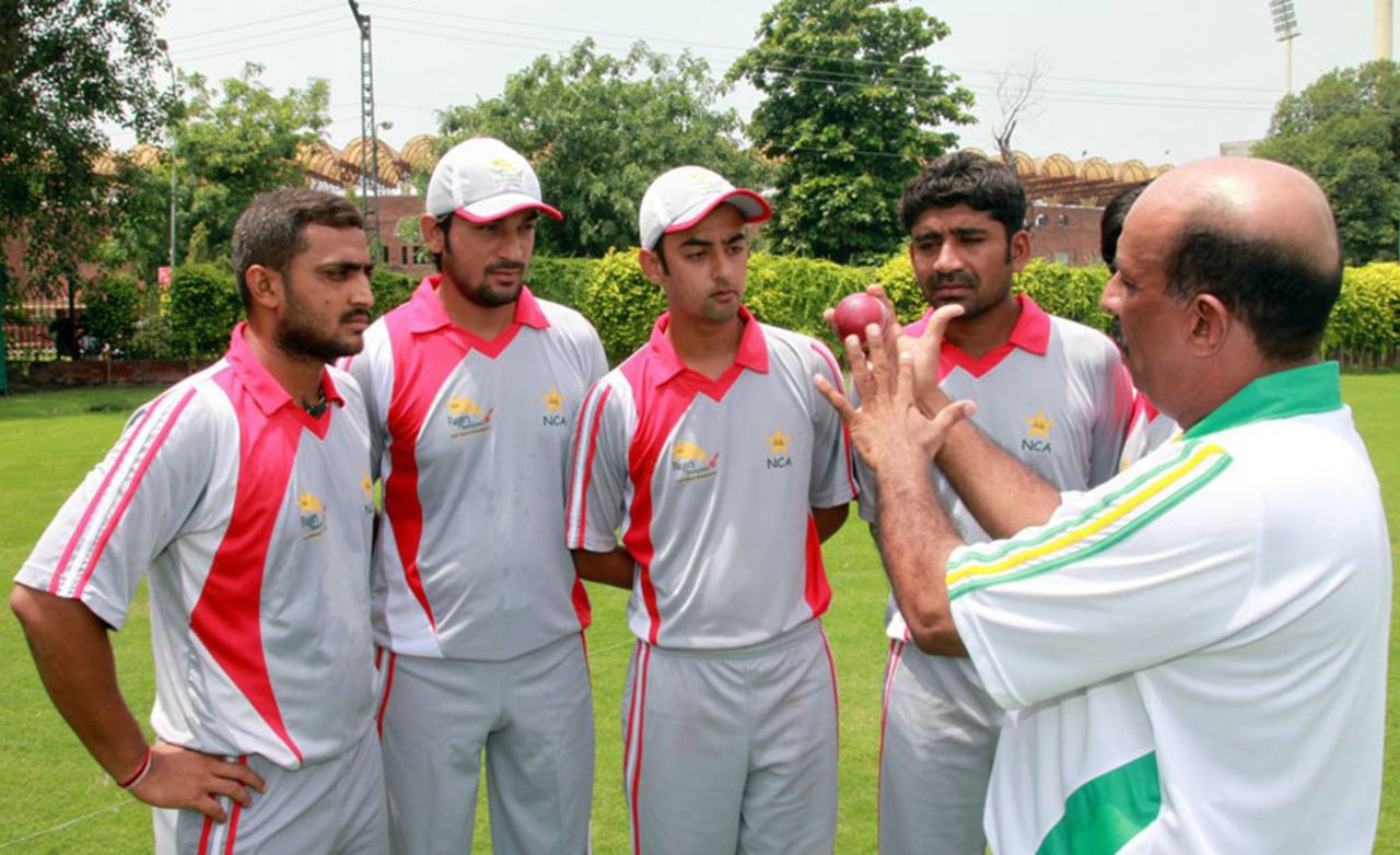 Tauseef Ahmed, the PCB's regional head coach for Hyderabad, illustrates a point while talking to young cricketers