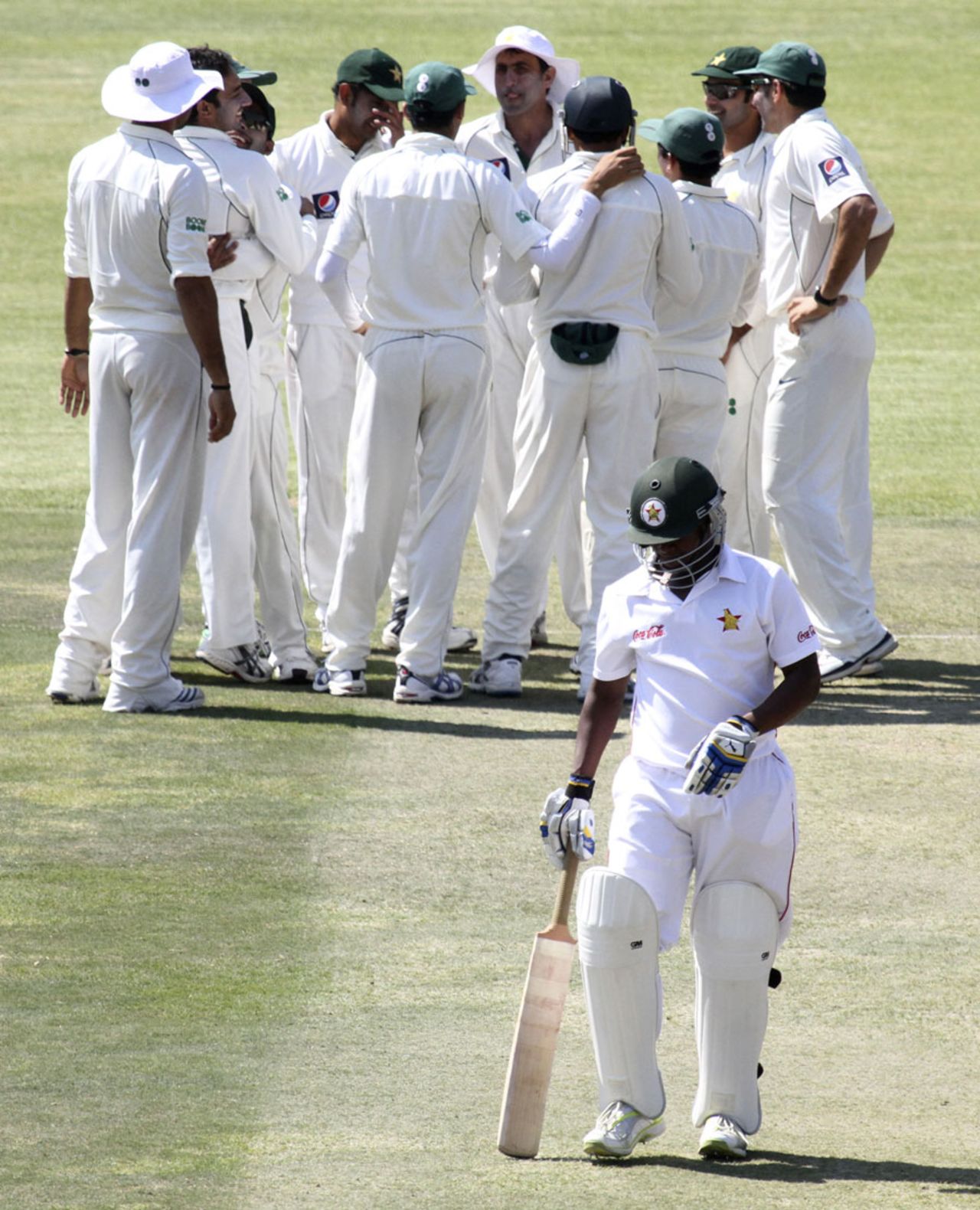 Tino Mawoyo walks off as Pakistan celebrate his dismissal, Zimbabwe v Pakistan, only Test, 4th day, Bulawayo, September 4, 2011