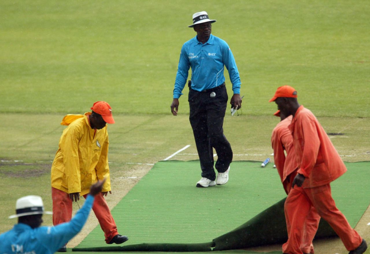 The umpires oversee the covering of the pitch, Zimbabwe v New Zealand, 2nd Twenty20, Harare, October 17, 2011