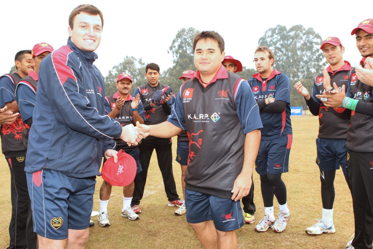 Hong Kong skipper Jamie Atkinson receives his new baggy red cap from Roy Lamsam before the start of the ACC Twenty20 Cup 2011 match against Nepal at the Tribhuvan University ground in Kathmandu on 3 December 2011 