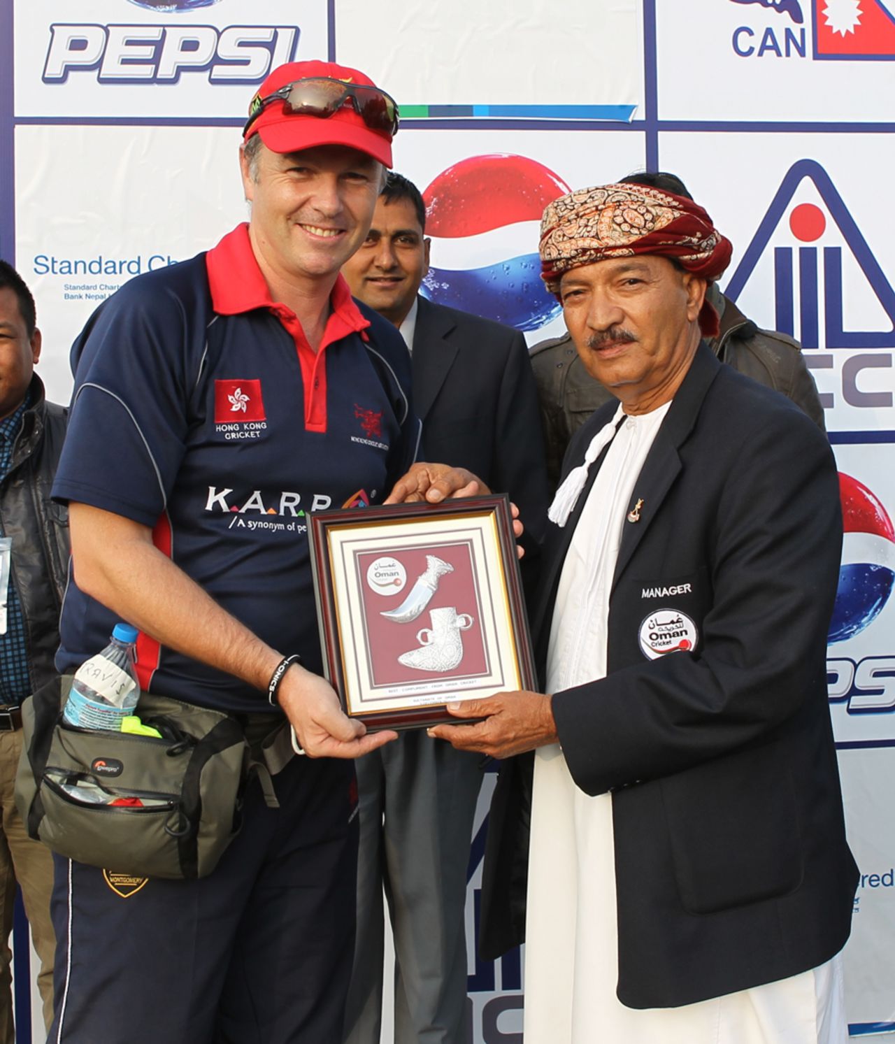 Hong Kong Team Manager Travis Pittman receives a gift from Oman Team Manager Dad Mohammad Al Abalushi following the conclusion of the ACC Twenty20 Cup 2011 semi-final at Kathmandu on 9th December 2011