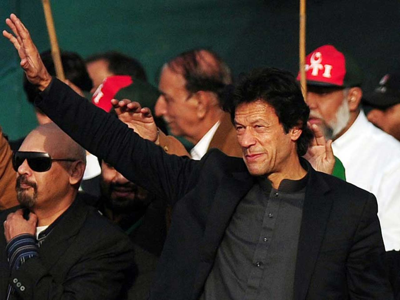 Imran Khan waves to the crowd at a political rally, Karachi, December 25, 2011
