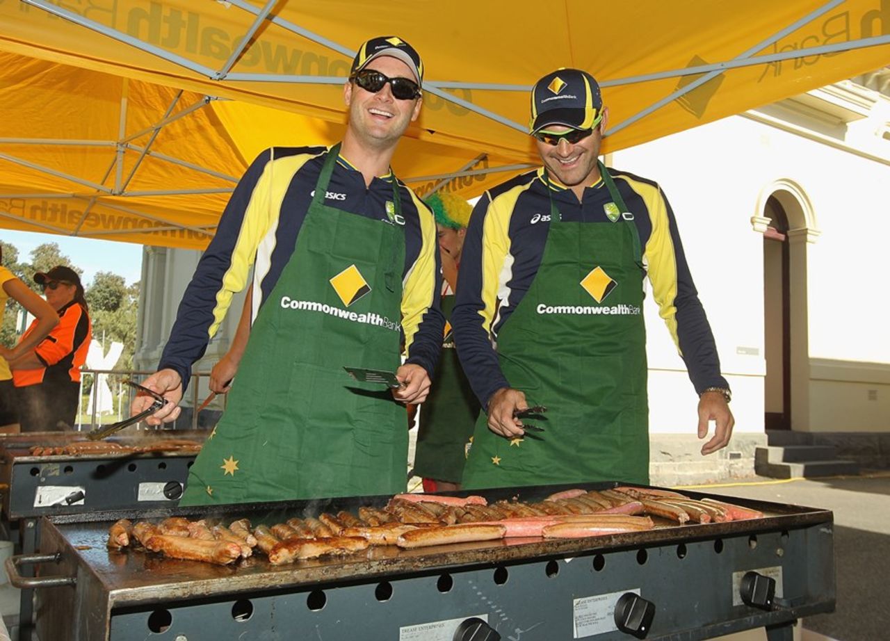 Michael Clarke and Ryan Harris cook sausages at a barbeque for the fans, Melbourne, February 4, 2012