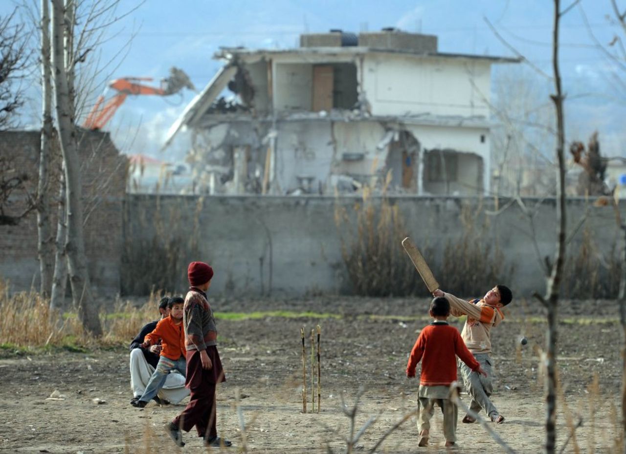 Children play cricket as the compound where Osama Bin Laden was found is demolished, Abbottabad, February 27, 2012