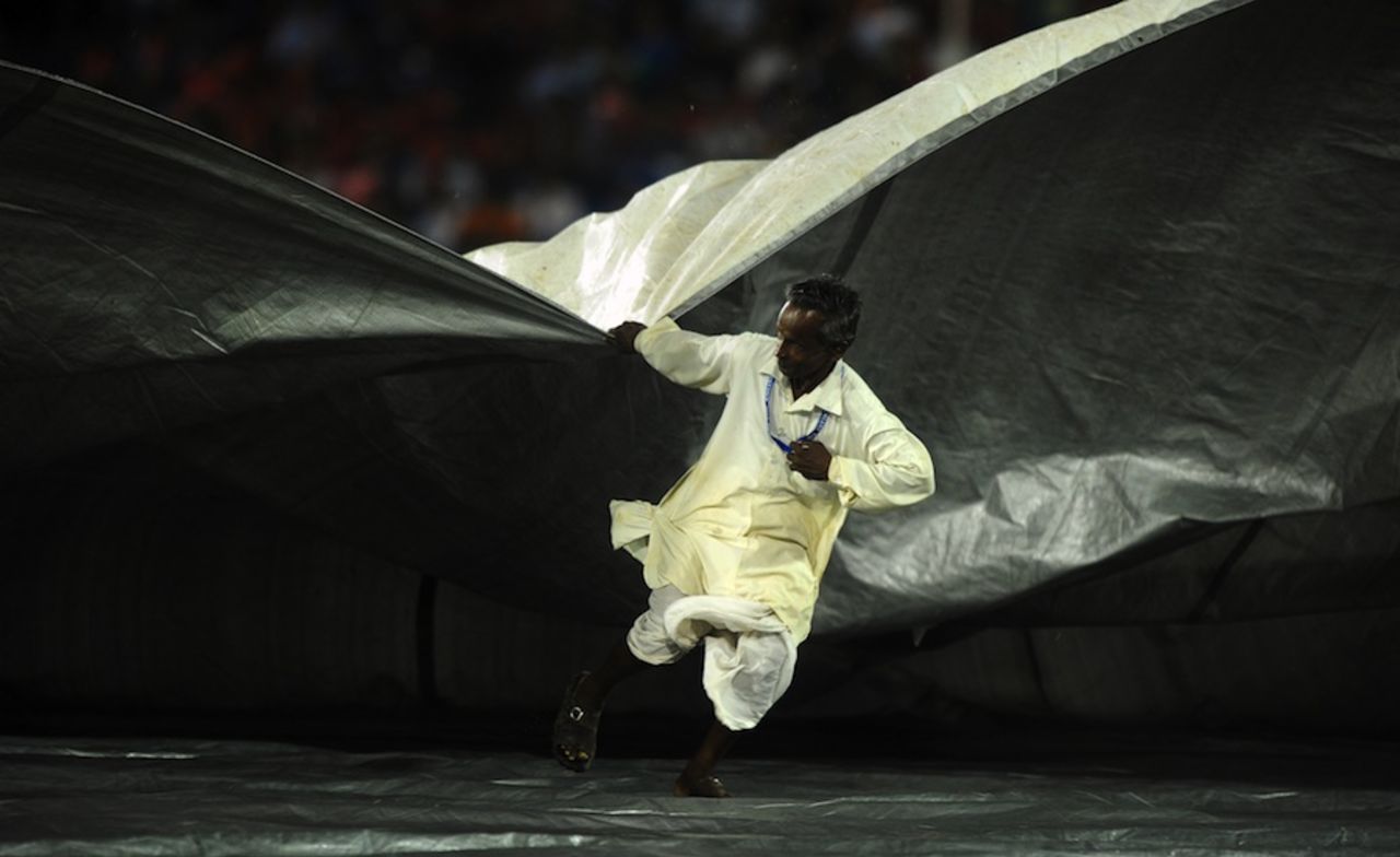 A member of the ground staff helps cover the pitch at the Barabati Stadium, Deccan Chargers v Kolkata Knight Riders, IPL, Cuttack, April 22, 2012
