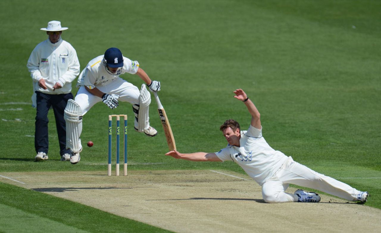 Jonathan Trott jumps in the air as James Anyon dives after the ball, Sussex v Warwickshire, County Championship, Division One, Hove, April 26, 2012
