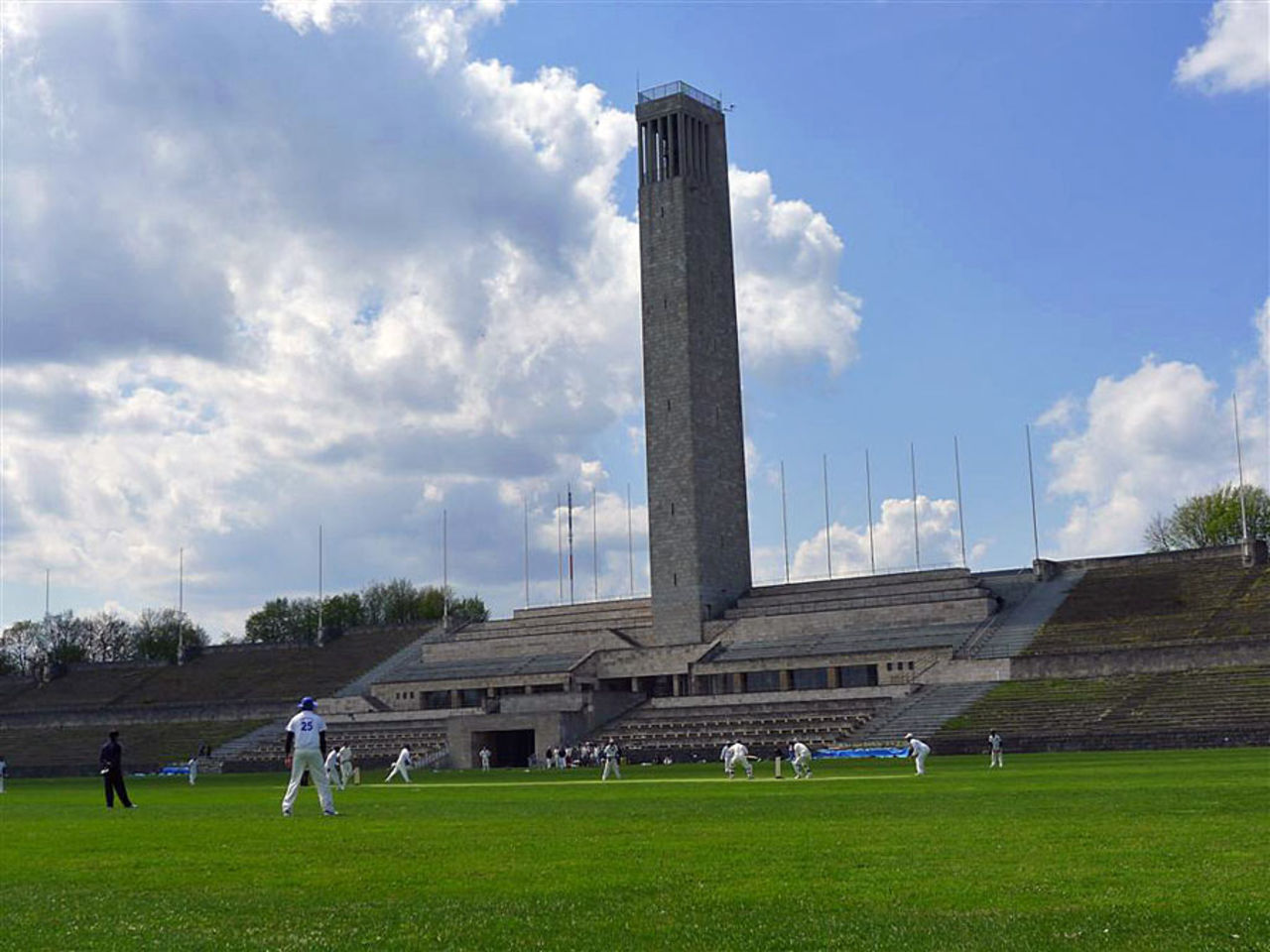 Maifeld, where the Berlin Cricket Club plays, with a historical bell tower in the background, Berlin