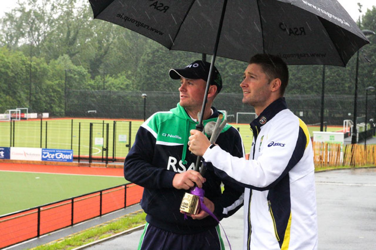 Michael Clarke and William Porterfield try to keep the RSA Challenge trophy dry, Belfast, June 22, 2012