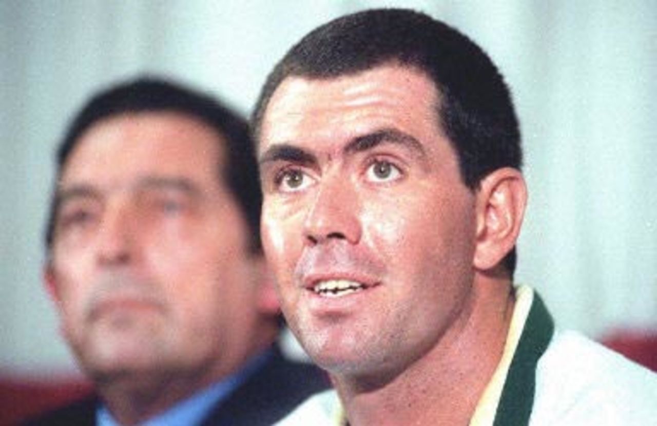 South African national cricket team captain Hansie Cronje speaks to the press while the united cricket board director Ali Bacher (L) looks on 09 April 2000, at the kingsmead cricket stadium in Durban. Cronje said the allegations of match-fixing in India had 'hurt' him but added he would be happy for an independent inquiry to examine his bank accounts in order to clear his name.