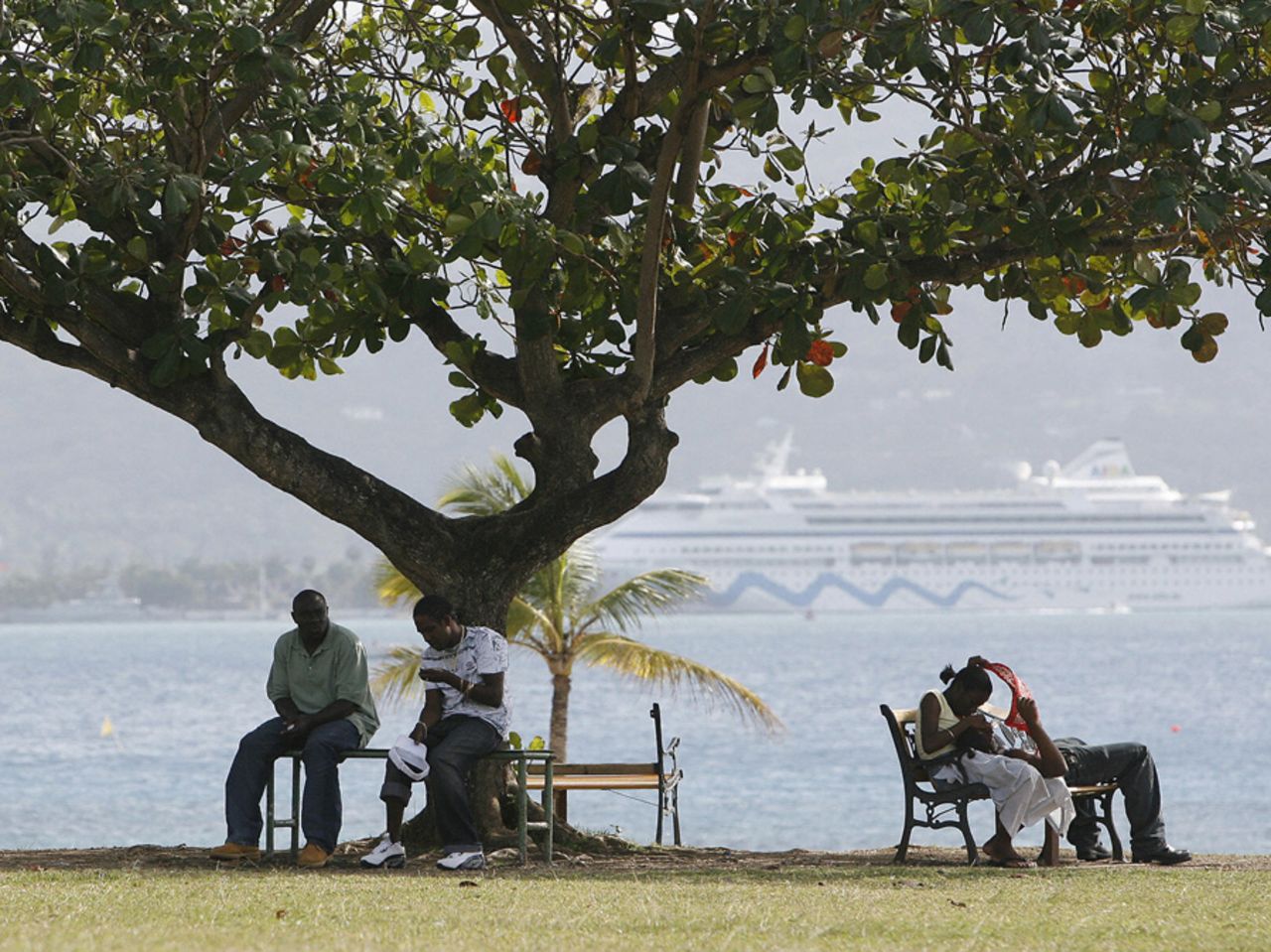 Locals and tourists sit by the sea at Montego Bay, Jamaica, March 10, 2007 