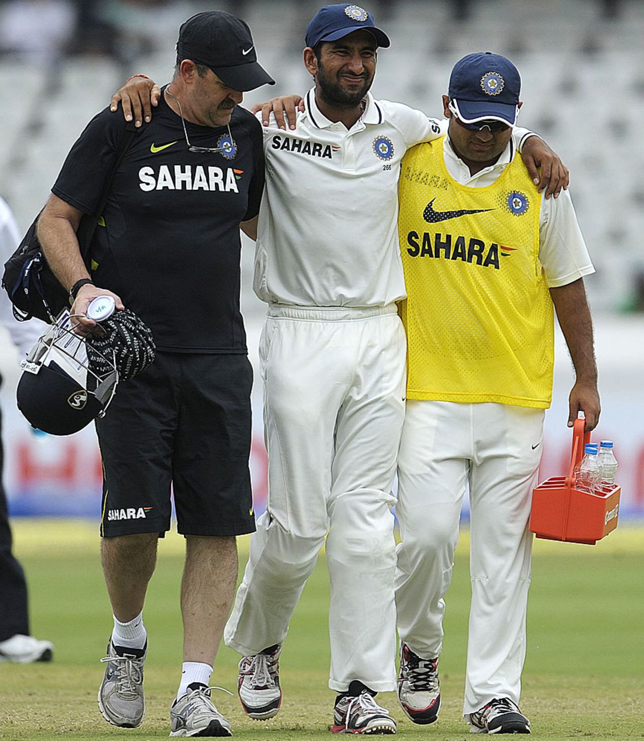 An injured Cheteshwar Pujara is led off the field, India v New Zealand, 1st Test, Hyderabad, 4th day, August 26, 2012