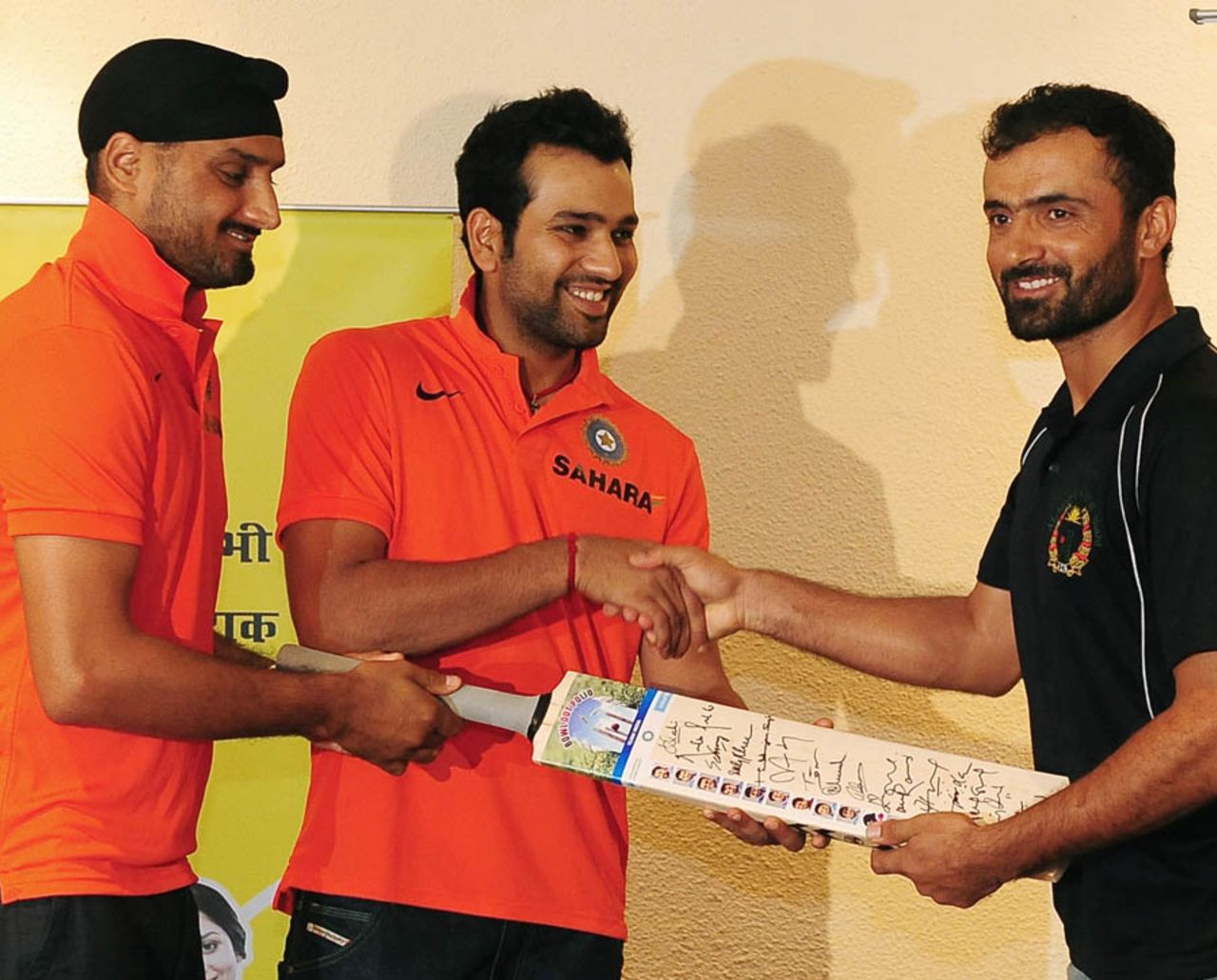 Rohit Sharma and Harbhajan Singh present a signed bat to Nawroz Mangal as part of a polio eradication programme, Colombo, September 18, 2012