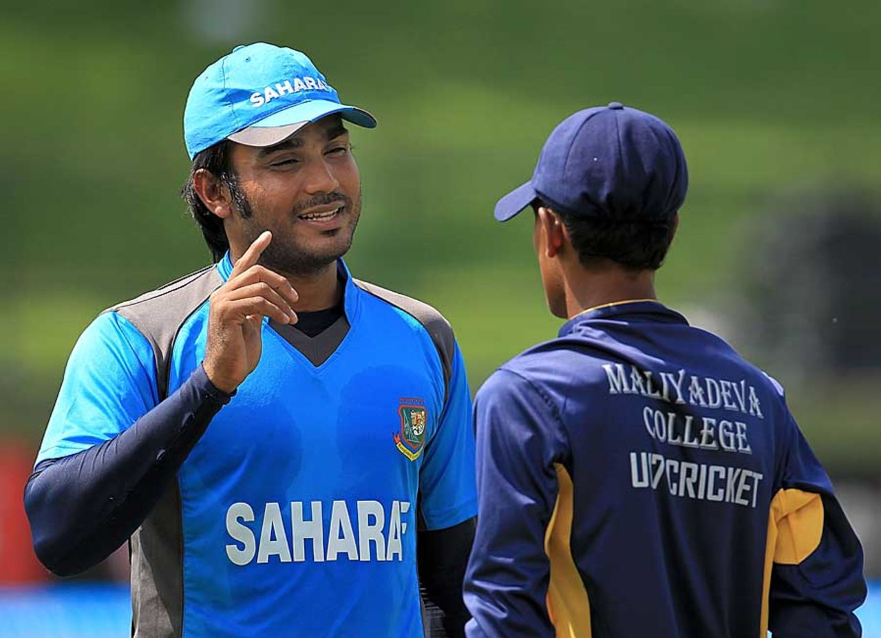 Junaid Siddique speaks to a budding cricketer at a cricket clinic in Pallekele, Pallekele, September 19, 2012