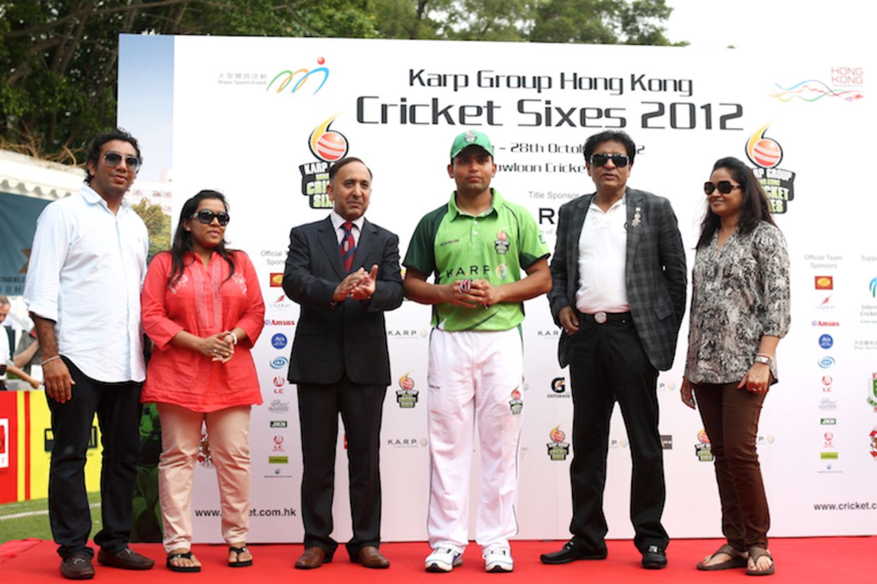 Umar Akmal receives his Player of the Tournament trophy from HKCA President Capt. Saleem Ahmed and members of the KARP Group delegation