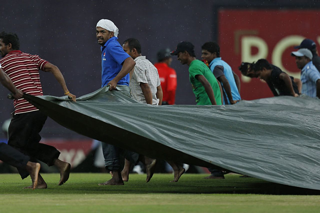 Groundsmen run to cover the ground after rain halts play, Sri Lanka v New Zealand, 3rd ODI, Pallekele, November 6, 2012