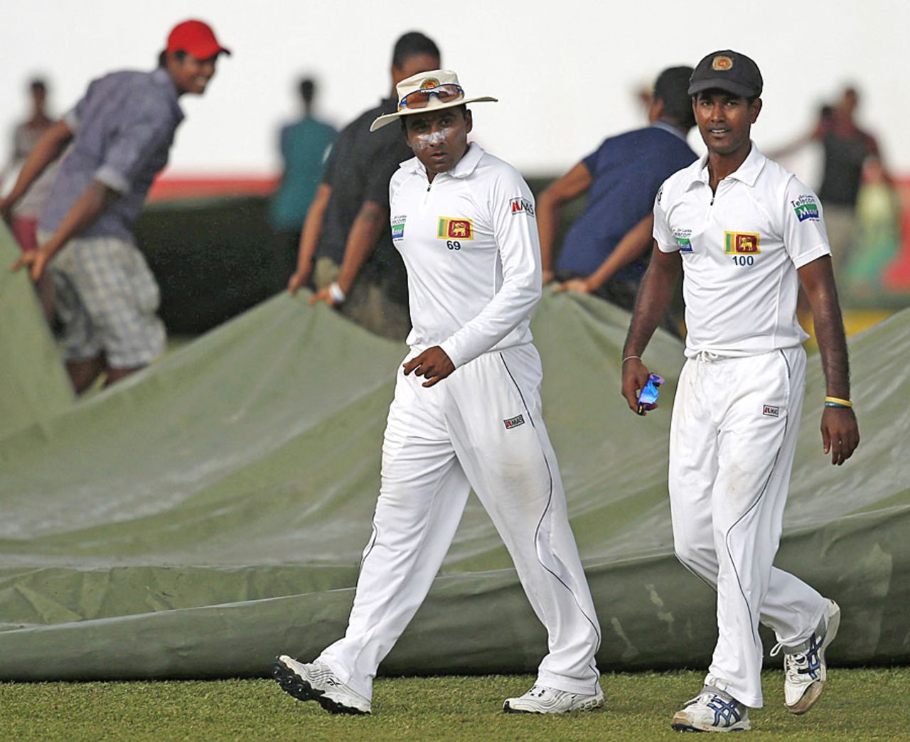 Mahela Jayawardene and Nuwan Kulasekara go off the field as the covers come on, Sri Lanka v New Zealand, 2nd Test, Colombo, 1st day, November 25, 2012