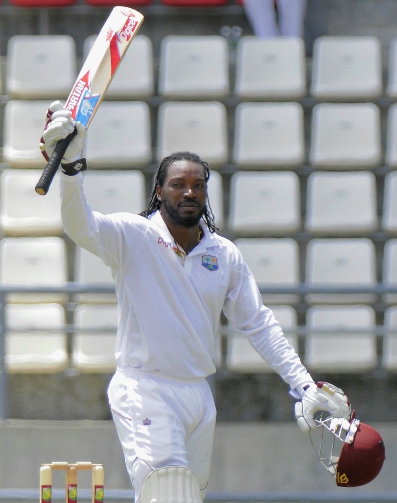 Chris Gayle raises his bat after reaching his hundred, West Indies v Zimbabwe, 2nd Test, Roseau, 2nd day, March 21, 2013