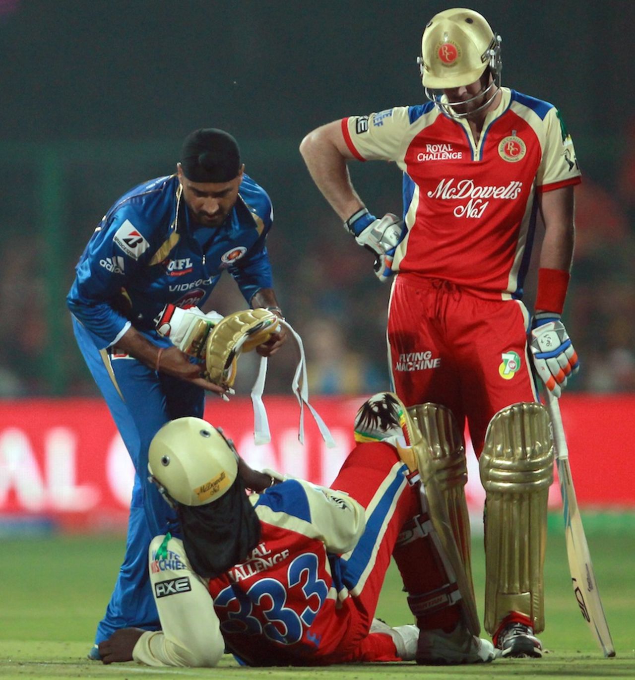 Harbhajan Singh helps Chris Gayle during an injury break, Royal Challengers Bangalore v Mumbai Indians, IPL, Bangalore, April 4, 2013