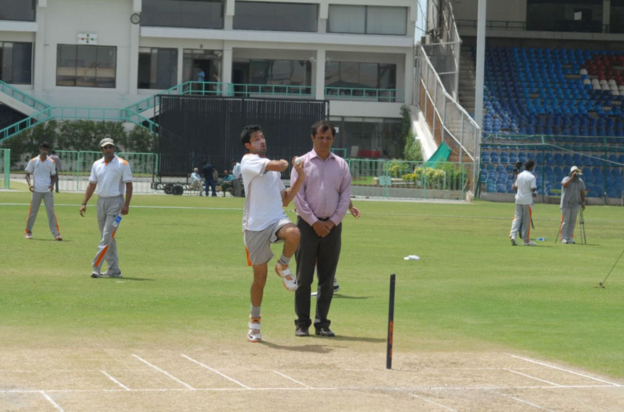 Junaid Khan about to bowl while Wasim Akram looks on in the distance, National Academy, Karachi, April 25, 2013