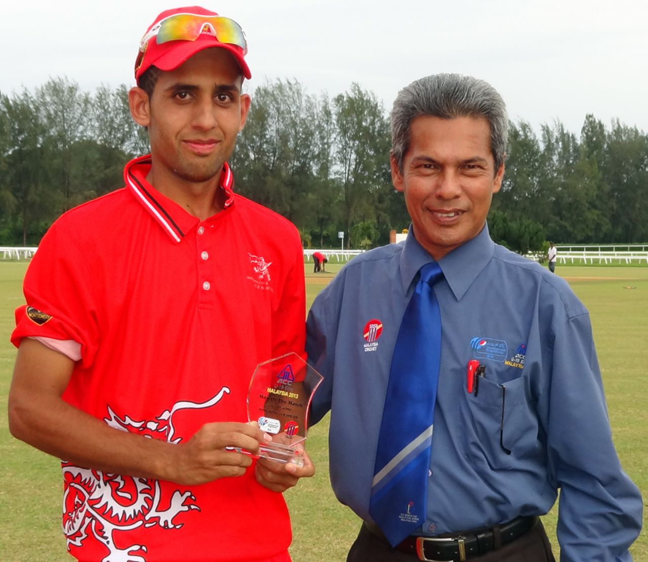 Waqas Khan receives his Man of the Match award from Match Referee Tan Kim Hing after scoring 60* and claiming 4-32 against Bahrain at the ACC Under-19 Elite 2013 in Kuala Lumpur on 10th May 2013