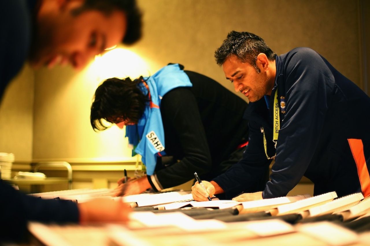 MS Dhoni signs cricket bats with team-mates ahead of the Champions Trophy, Birmingham, May 30, 2013