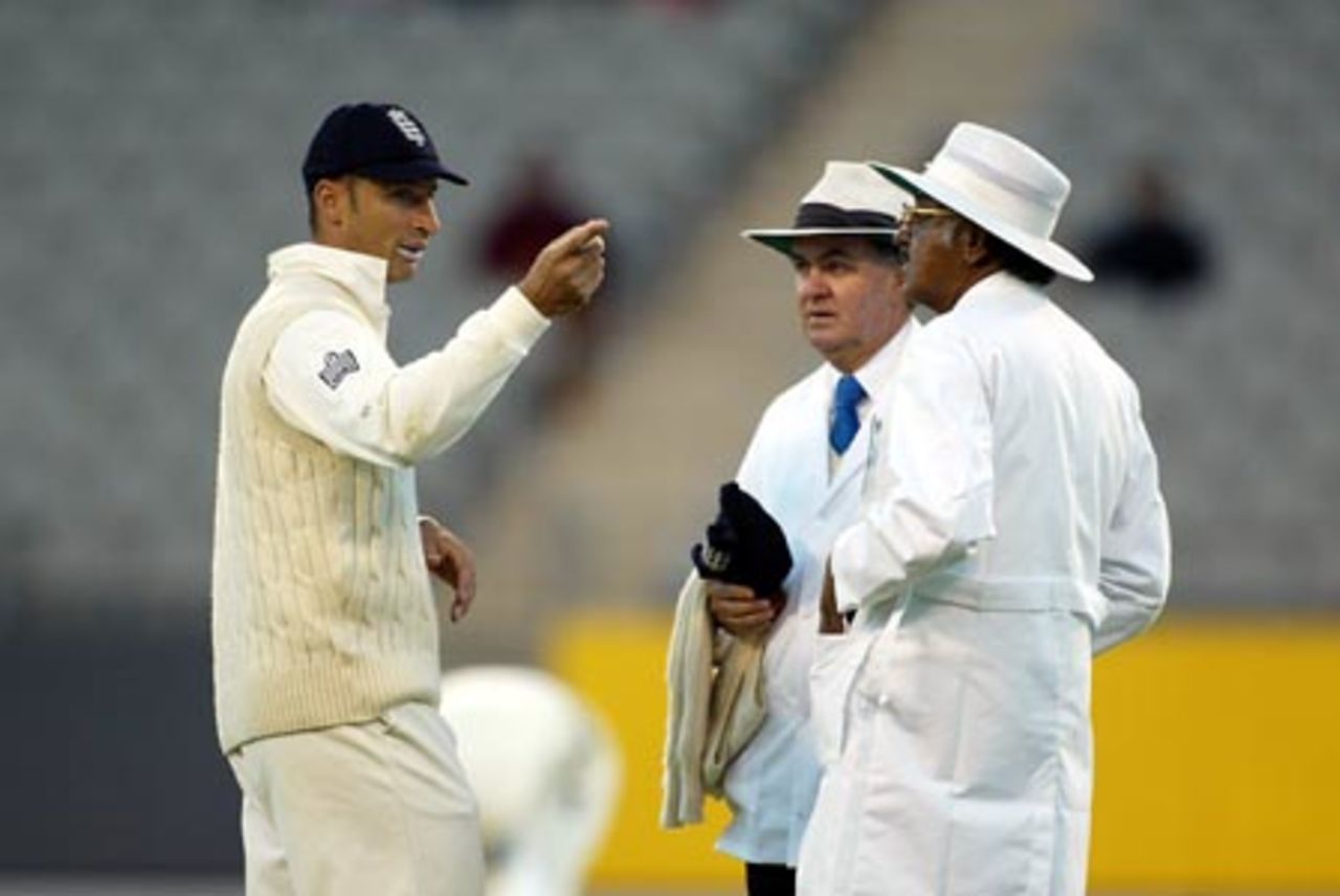 England captain Nasser Hussain (left) discusses the light conditions with umpires Doug Cowie (centre) and Srinivas Venkataraghavan from India. The umpires allowed play to continue under artificial lighting until the scheduled minimum number of overs were bowled. 3rd Test: New Zealand v England at Eden Park, Auckland, 30 March-3 April 2002 (2 April 2002).