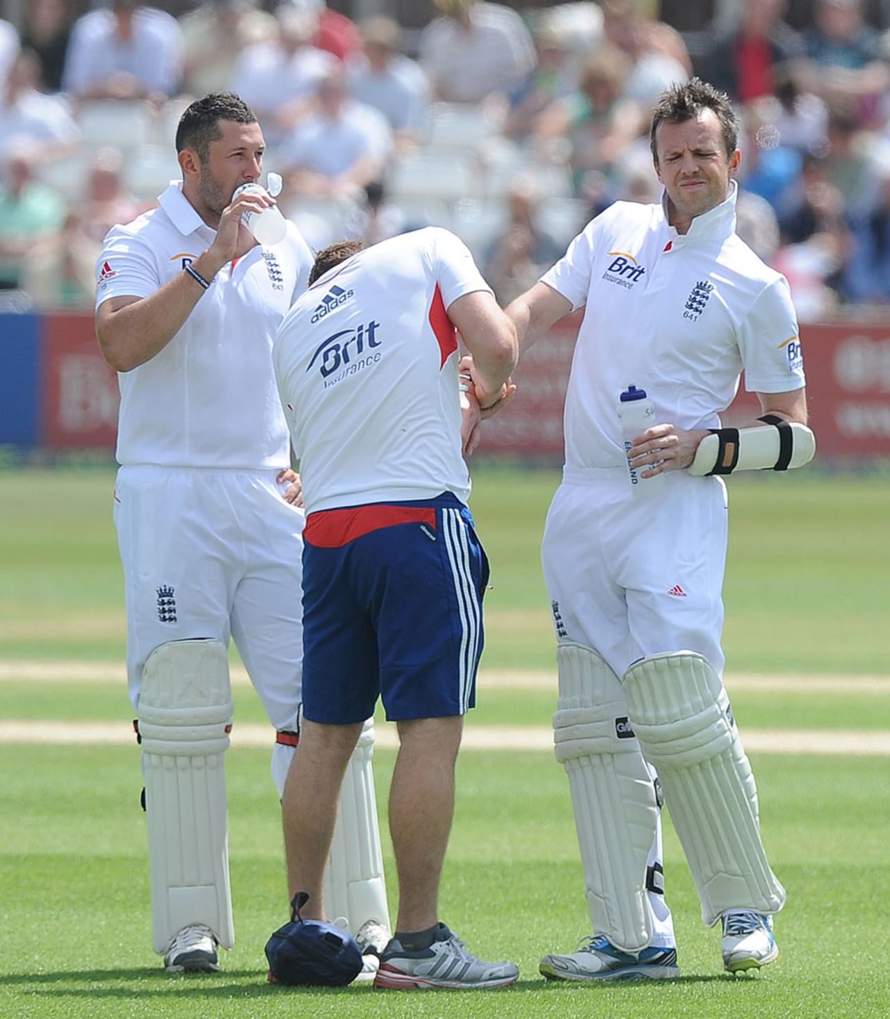 Tim Bresnan looks on as Graeme Swann receives treatment on his right arm, Essex v England, 2nd day, Chelmsford, July 1, 2013