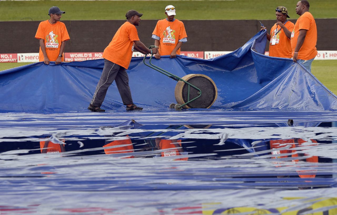 Groundstaff mop up water from the covers, India v Sri Lanka, West Indies tri-series, Port-of-Spain, July 9, 2013