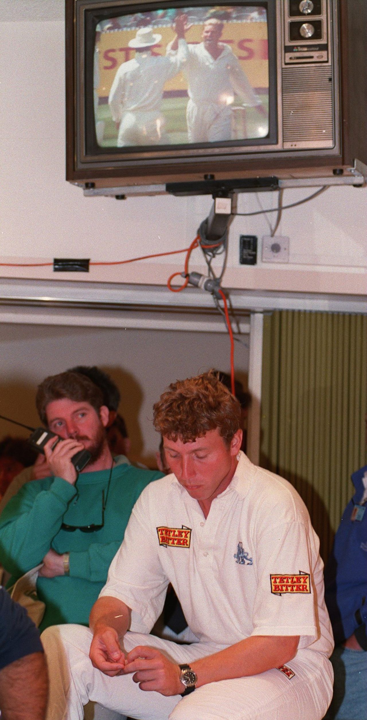 Michael Atherton sits dejected at a press conference while a TV replays Australia's victory in Melbourne, Australia v England, 2nd Test, Melbourne, 5th day, December 29, 1994