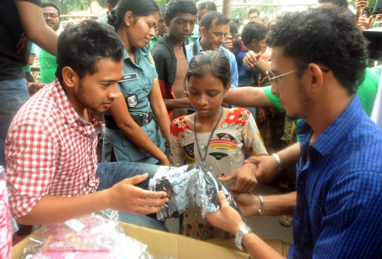 Mushfiqur Rahim and Nasir Hossain distribute Eid clothes to poor children at the Kamalapur Railway Station, Dhaka, August 4, 2013