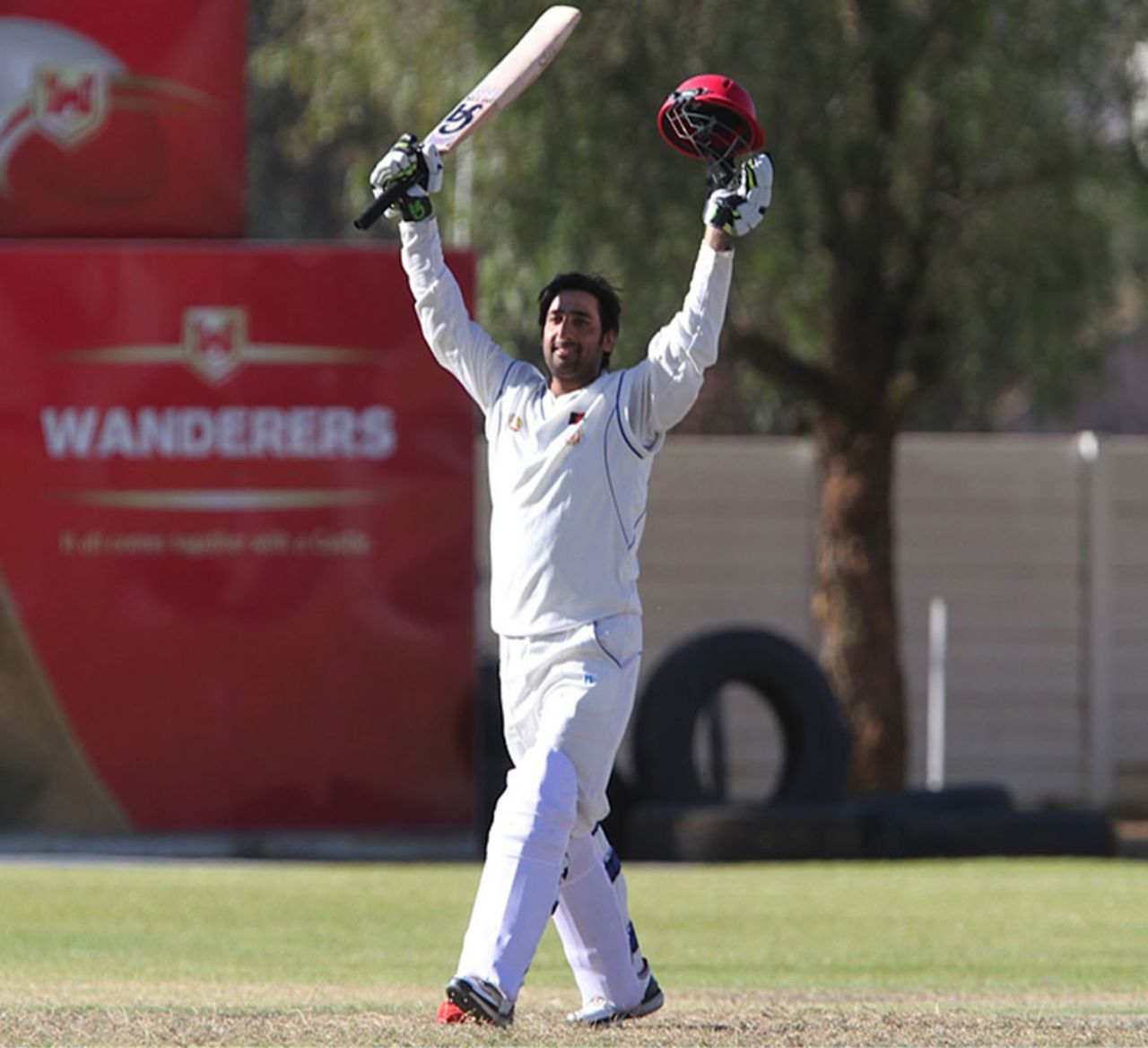 Asghar Stanikzai raises his bat after reaching his century, Namibia v Afghanistan, ICC Intercontinental Cup, 2nd day, Windhoek, August 5, 2013
