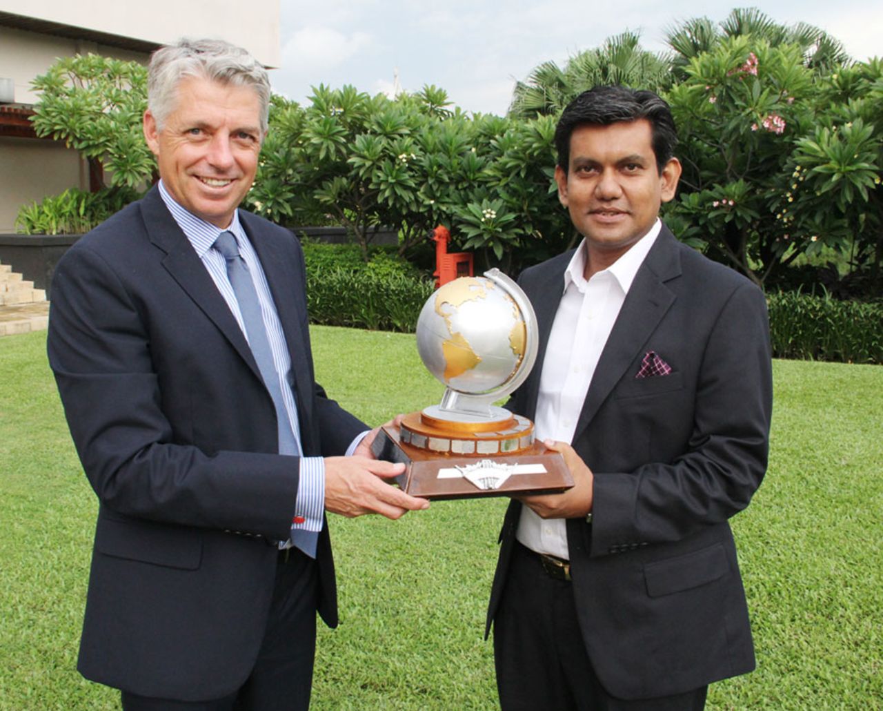 ICC CEO David Richardson hands over a replica of the 1997 ICC trophy to the BCB acting CEO Nizam Uddin Chowdhury, Dhaka, August 13, 2013