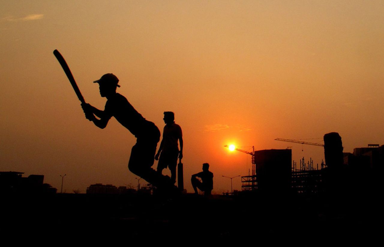 Youngsters play street cricket in Mumbai, March 11, 2010
