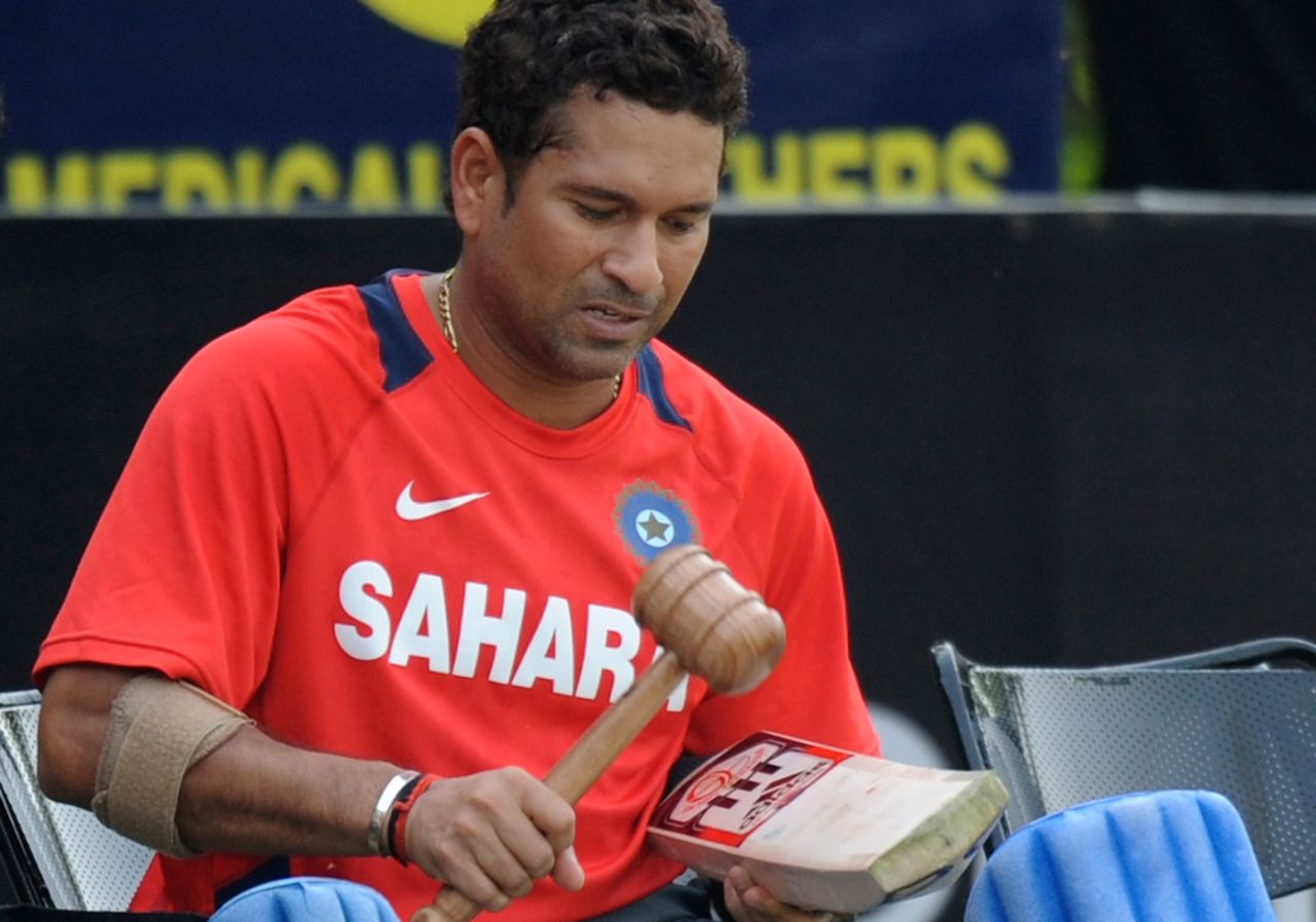 Sachin Tendulkar seasons his bat with a special hammer during a training session, Mohali, March 28, 2011