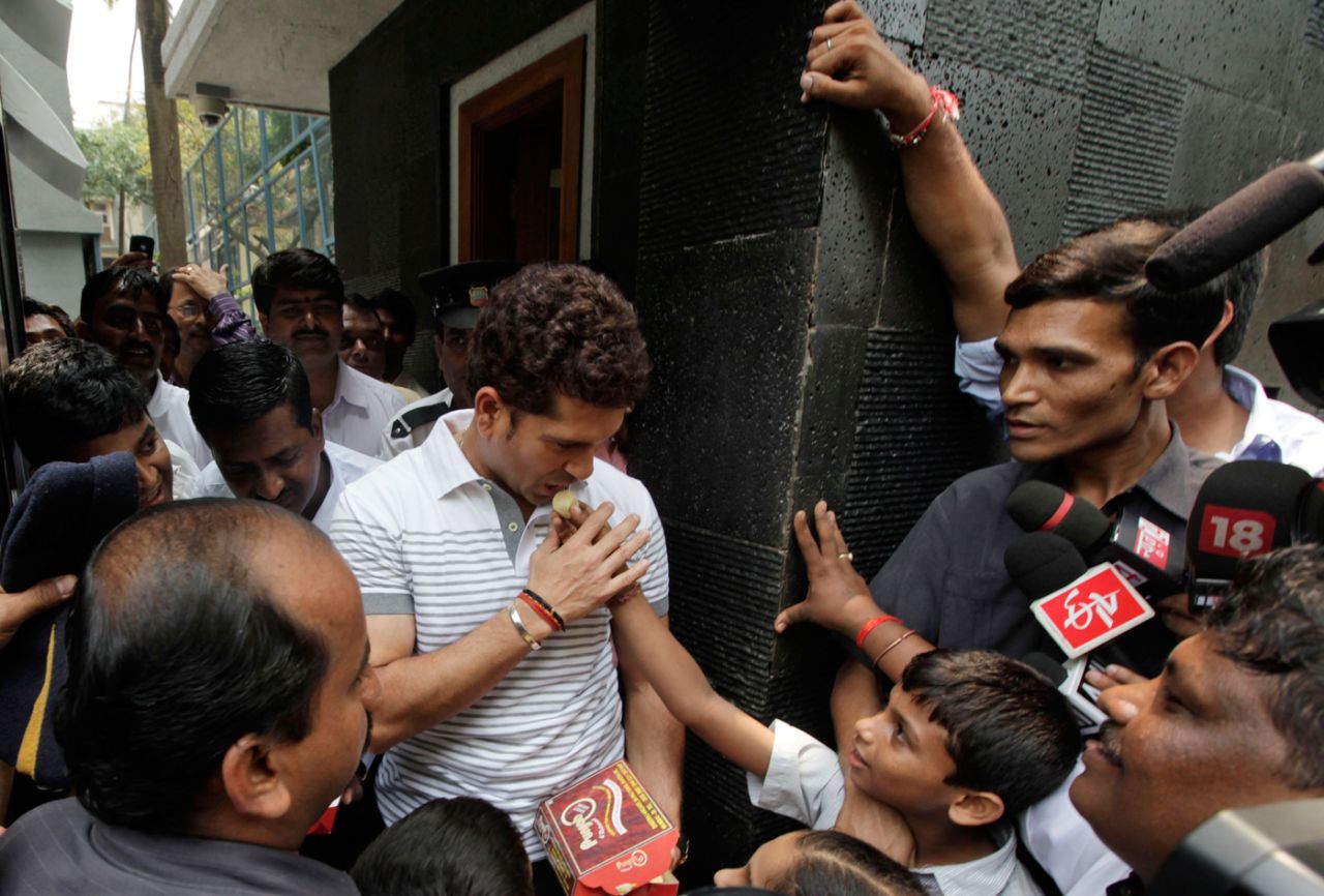 Sachin Tendulkar accepts sweets from school children who came to welcome him after he moved into his new home in Bandra, Mumbai, September 28, 2011