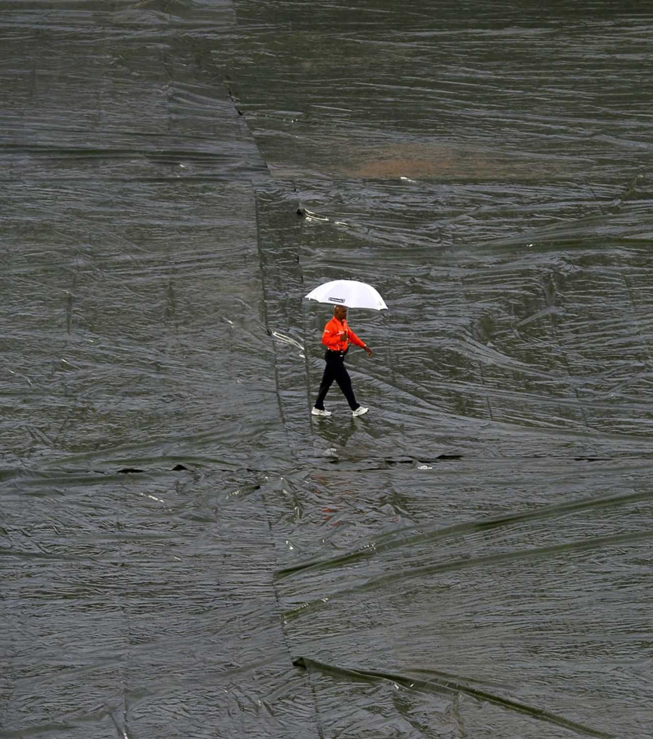 Umpire Raveendra Wimalasiri walks over the covers, Sri Lanka v New Zealand, 2nd ODI, Hambantota, November 12, 2013