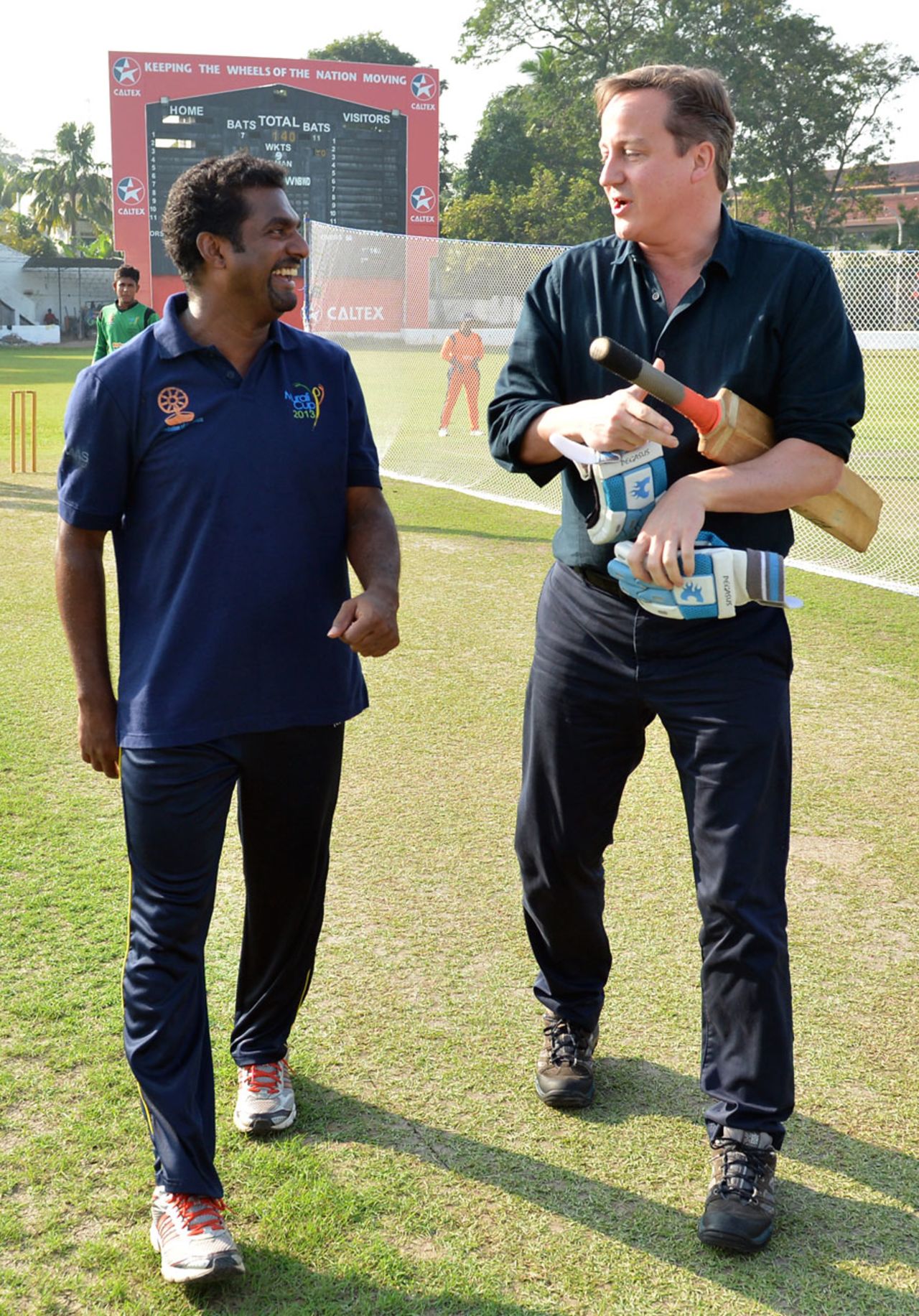 UK Prime Minister David Cameron chats with Muttiah Muralitharan at a charity event, Colombo, November 16, 2013