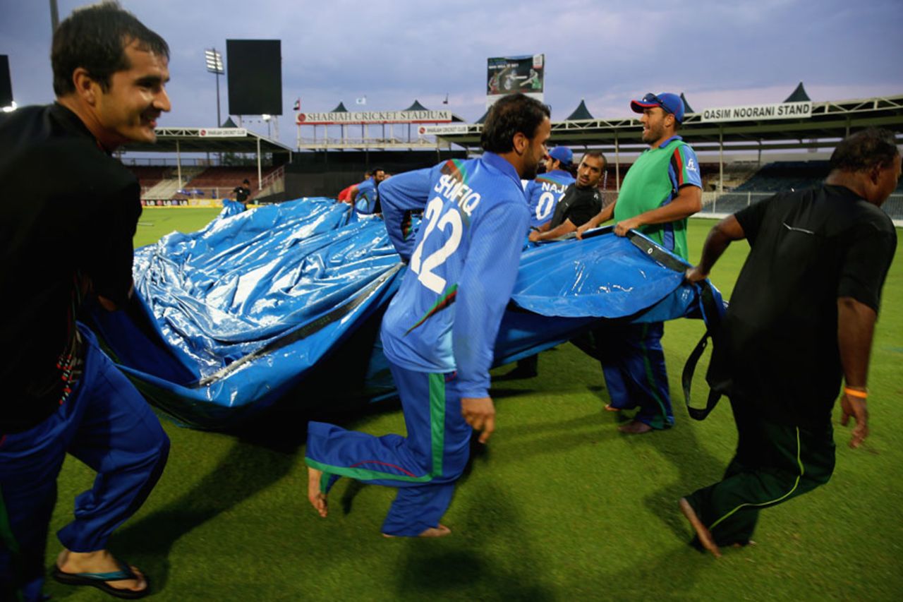 Afghanistan players help clear the covers off the ground, PNG v Afghanistan, ICC World Twenty20 Qualifier, Group B, Sharjah, November 17, 2013