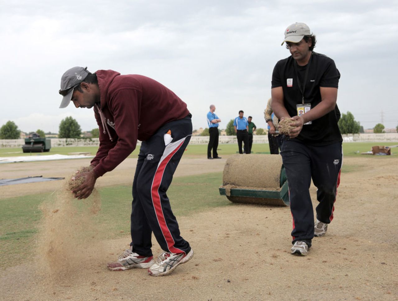 Ground staff put sawdust on patches of wet outfield, Uganda v United States of America, ICC World Twenty20 Qualifier, Group A, Abu Dhabi, November 21, 2013