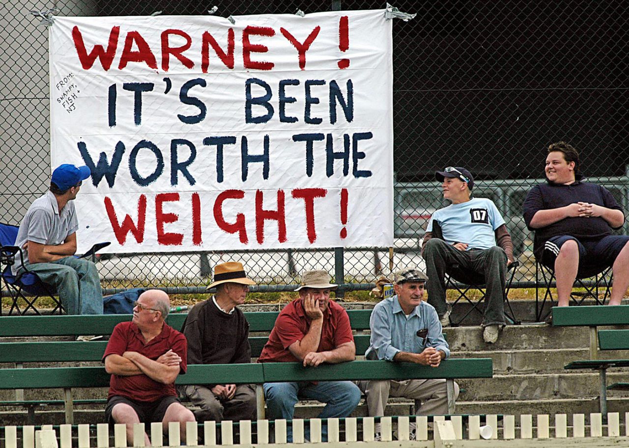 Spectators look at a sign put up for Shane Warne in his comeback game for Victoria 2nd XI, Junction Oval, Melbourne, February 10, 2004