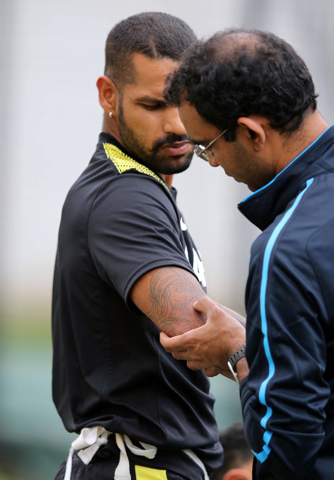Shikhar Dhawan has his right elbow checked by the physio Nitin Patel, Durban, December 7, 2013