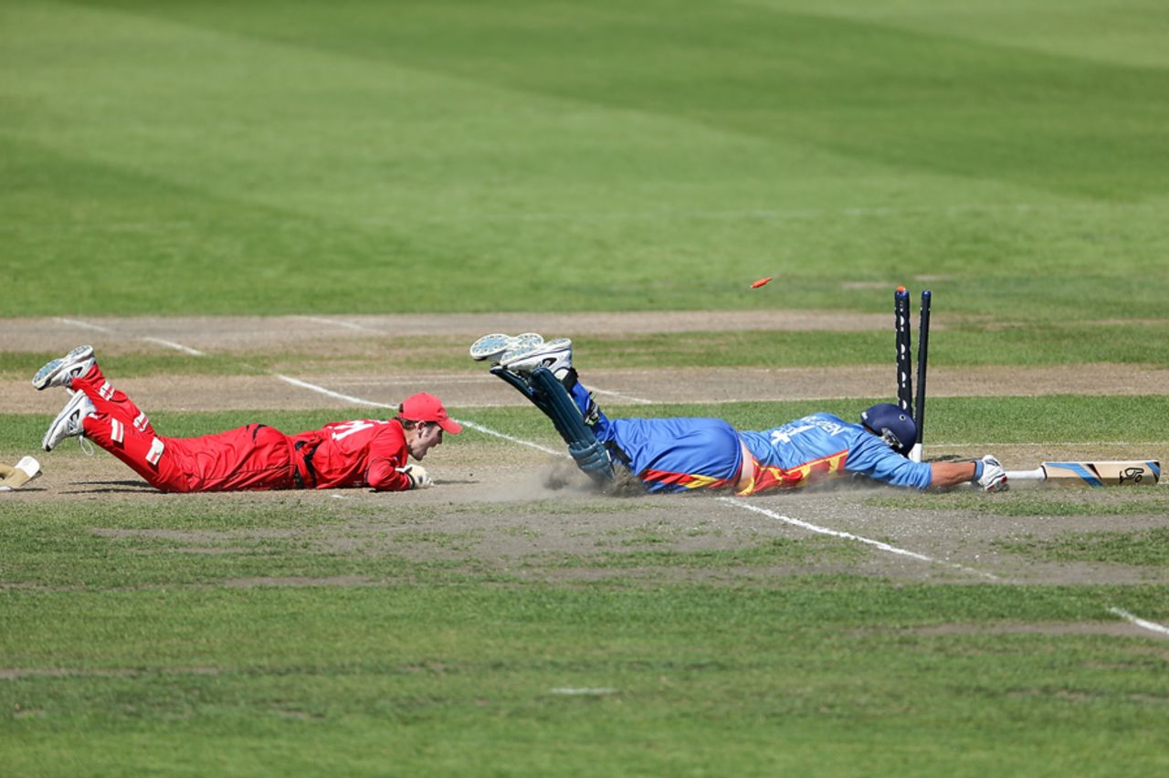 Mark Ferguson (L) of Hong Kong attempts to run out Christi Viljoen (R) of Namibia during the ICC Cricket World Cup Qualifier match between Namibia and Hong Kong at Mainpower Oval on January 28, 2014 in Rangiora, New Zealand. (Photo by Martin Hunter-IDI/IDI via Getty Images)