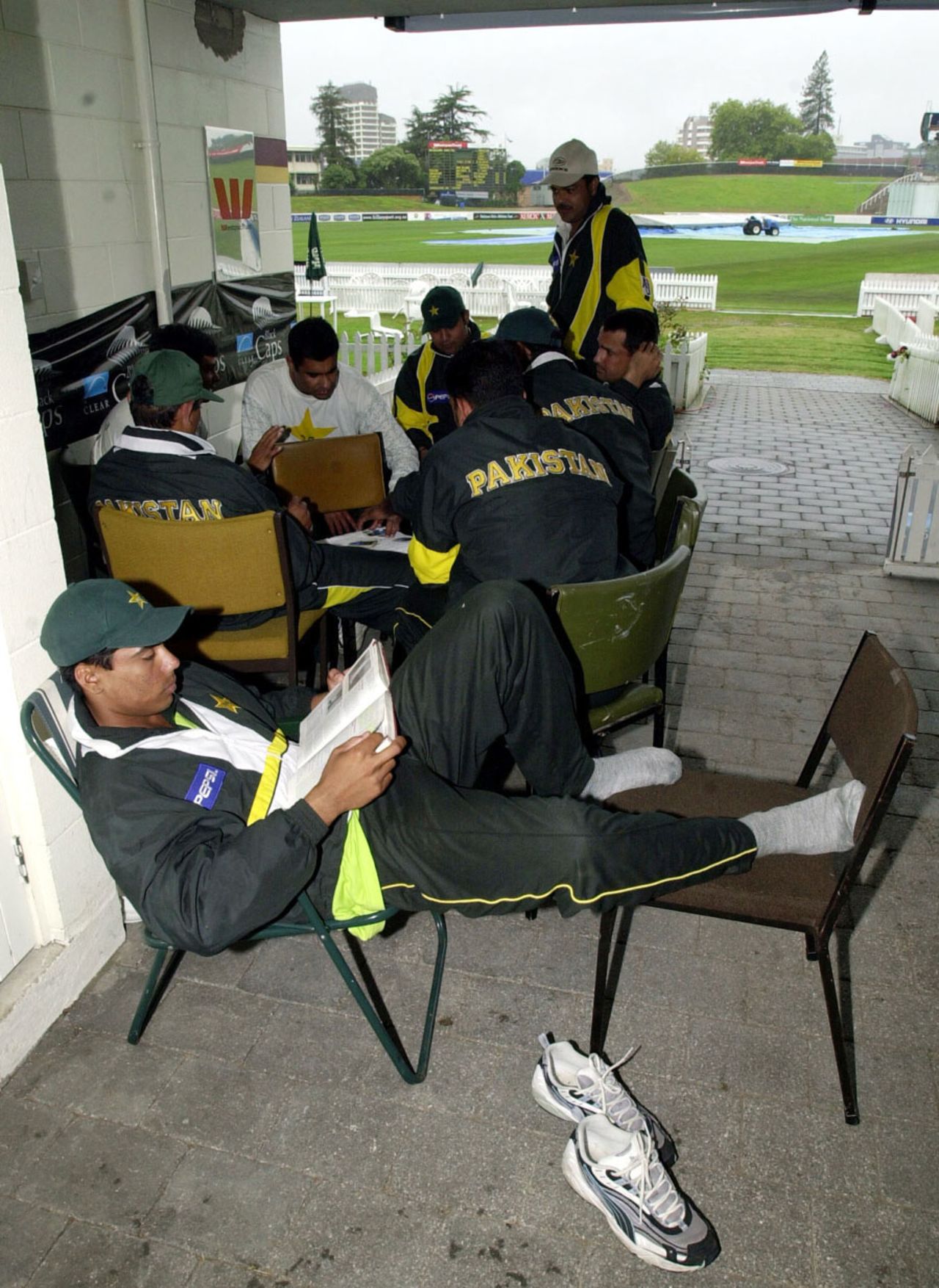 Mohammad Sami reads a book while his team-mates play cards during a rain delay, New Zealand v Pakistan, 3rd Test, Hamilton, 2nd day, March 28, 2001
