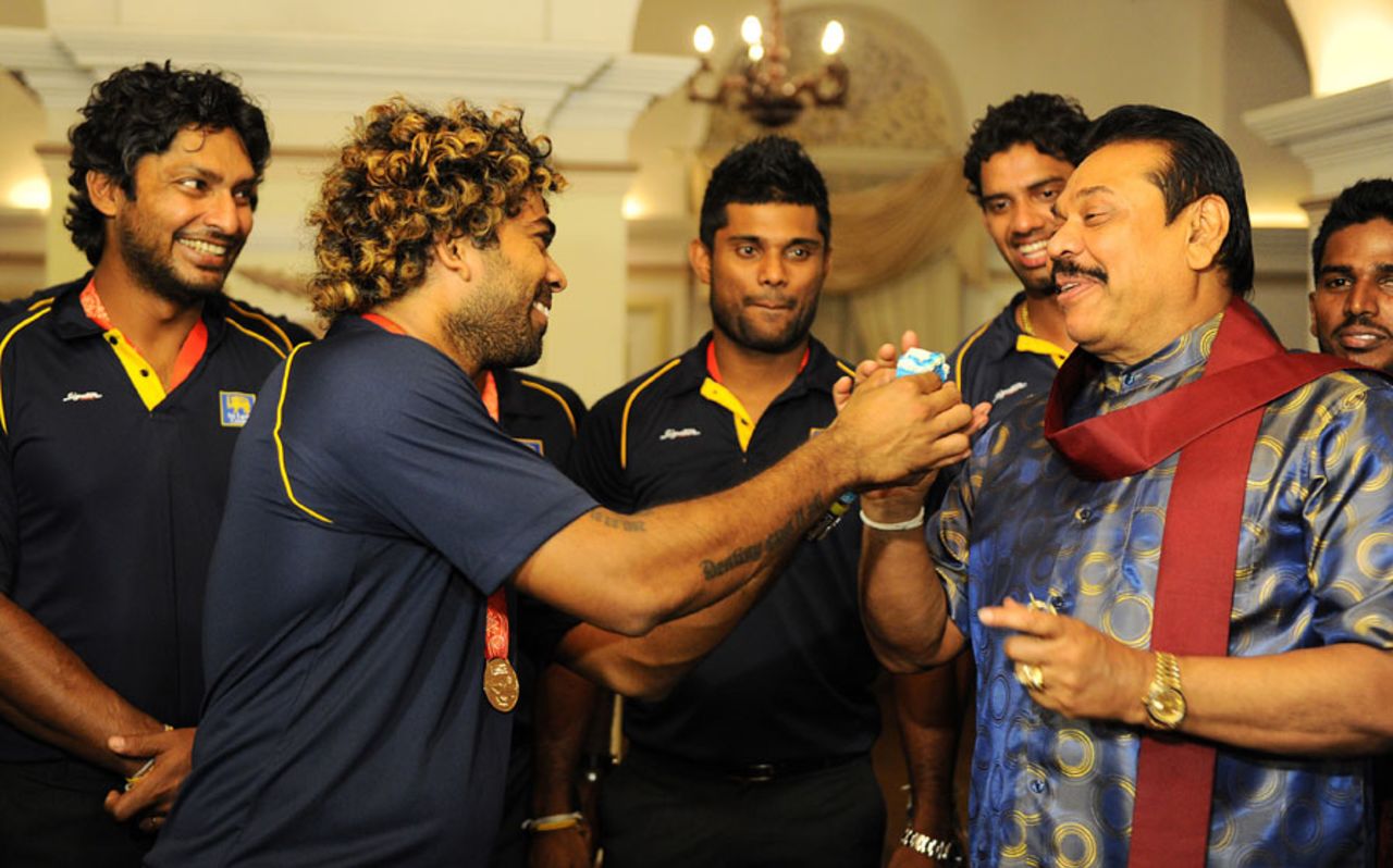 Lasith Malinga offers a piece of cake to the Sri Lankan president Mahinda Rajapakse, Colombo, April 8, 2014