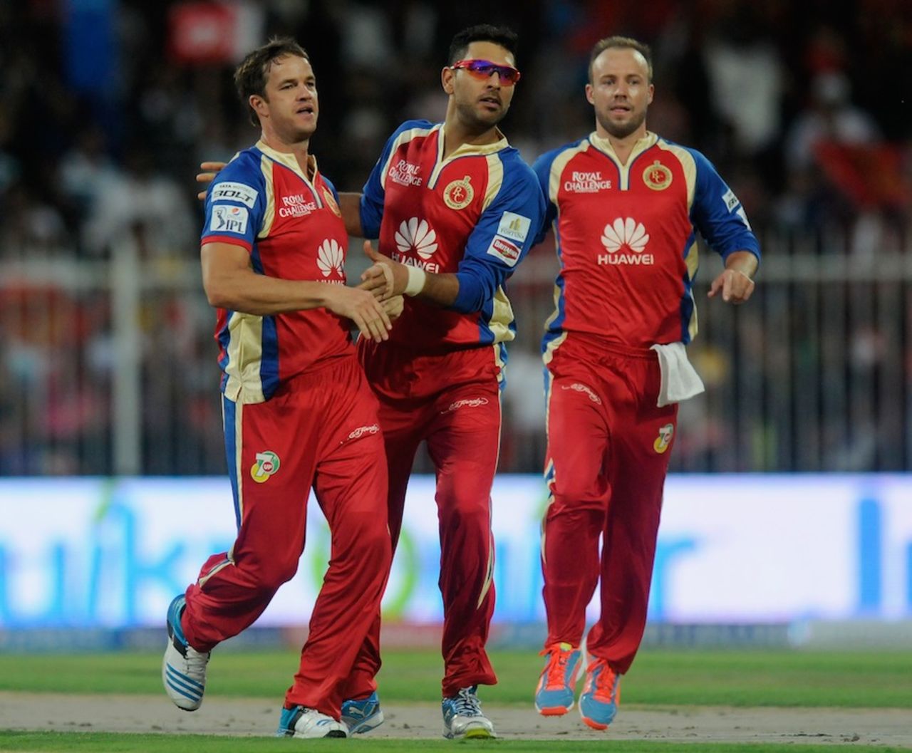 Albie Morkel, Yuvraj Singh and AB de Villiers celebrate a wicket, Royal Challengers Bangalore v Delhi Daredevils, IPL 2014, Sharjah, April 17, 2014