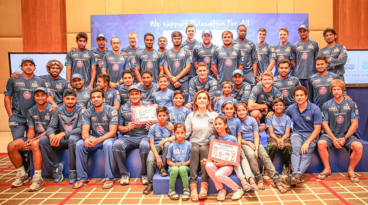 Mumbai Indians players and staff pose with nine underprivileged children from Mumbai as part of the 'Education for All' initiative, Dubai, April 18, 2014